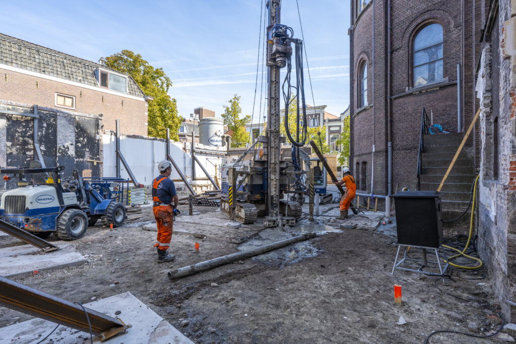 De eerste paal in Leiden wordt erin geschroefd.