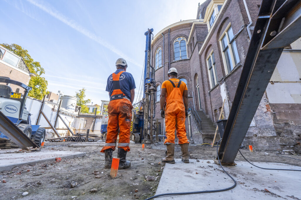 De eerste paal in Leiden wordt erin geschroefd.
